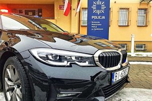 Radiowóz policyjny marki BMW na tle Komendy Powiatowej Policji w Zambrowie.