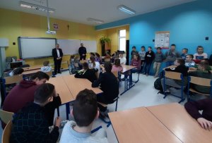 Dzielnicowy wspólnie z Dyrektorem Szkoły Podstawowej w Kołakach Kościelnych oraz zgromadzone dzieci i młodzież podczas prelekcji.