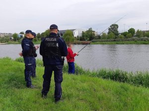 Umundurowani Policjanci legitymują wędkarza nad za Zalewem Miejskim.