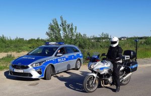 Policjanci ruchu drogowego w oznakowanym radiowozie oraz na motocyklu.