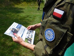 Licealista przeglądający ulotkę promującą służbę w Policji.