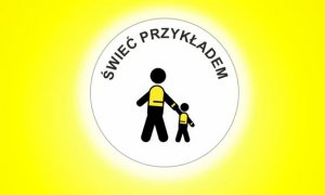 Na żółtym jaskrawym tle, w białym kółeczku, czarne postacie w kształcie osoby dorosłej i dziecka w kamizelkach odblaskowych. Na górze napis ŚWIEĆ PRZYKŁADEM.