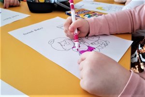 Dziecko koloruje obrazek tematyczny z okazji Dnia Babci.
