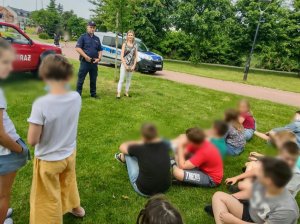 Przedstawicielka komendy oraz policjanta na zalewam podczas lekcji z uczniami.