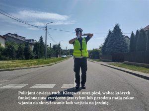 Policjant podczas kierowania ruchem. Na dole napis: Policjant zaraz otworzy ruch. Jeśli policjant kierujący ruchem jest zwrócony przodem lub tyłem do nadjeżdżających pojazdów, oznacza to zakaz wjazdu na skrzyżowanie, a dla pieszych – zakaz wejścia na jezdnię.