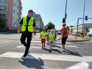 Policjant podczas przejścia przez jezdnię z przedszkolakami.