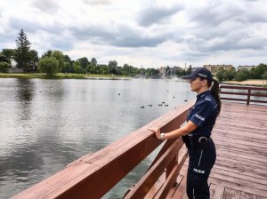 Policjantka stojąca na moście podczas kontroli zbiornika wodne, który jest w tle.