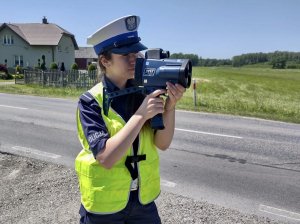 Policjantka ruchu drogowego podczas wykonywania pomiaru prędkości.