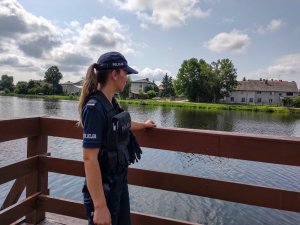 Policjantka stojąca na moście podczas kontroli akwenu wodnego.