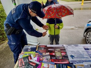 Policjant zakłada dziecku na rękę odblask.