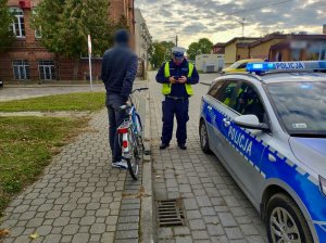 Policjanct podczas kontroli kierowcy roweru.