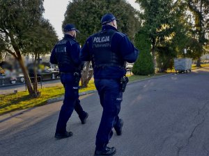 Umundurowani policjanci podczas patrolu na cmentarzu.