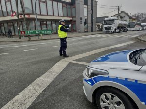 Policjant kierujący ruchem na drodze podczas przemarszu.