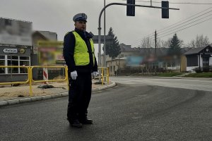 Policjant kierujący ruchem na drodze podczas przemarszu.