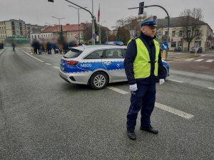 Policjant kierujący ruchem na drodze podczas przemarszu.