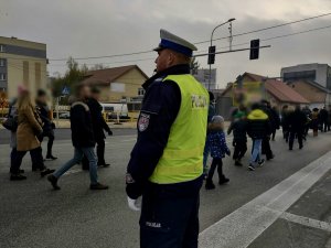 Policjant kierujący ruchem na drodze podczas przemarszu.