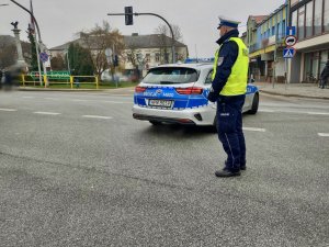 Policjant kierujący ruchem na drodze podczas przemarszu.