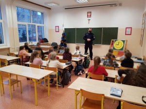 Policjant oraz profilaktyk podczas spotkania z uczniami w szkole.