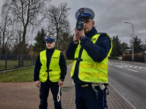 Umundurowani policjanci w kamizelkach odblaskowych podczas kontroli prędkości w Zambrowie.