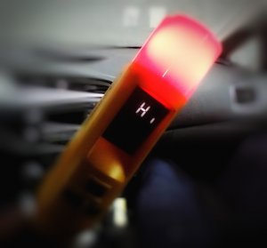 Urządzenie alkoblow do badania stanu trzeźwości z lampką świecąca na czerwono.
