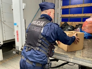 Policjant podczas przekazywania paczek z żywnością dla obywateli Ukrainy.