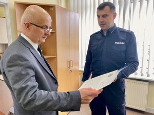 W pomieszczeniu biurowym Zastępca Komendanta Powiatowego Policji w Zambrowie wręczając podziękowania Panu Naczelnikowi Banku Pocztowego.