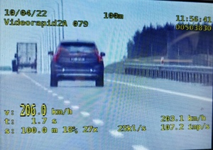 Na dole i górze ekranu dane z wideorejestratora. Radiowóz wykonujący pomiar jadącego przed nim pojazdu  z wynikiem 206 kilometrów na godzinę.