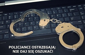 Na klawiaturze leżą kajdanki, a na dole napis &amp;quot;Policjanci ostrzegają, nie daj się oszukać&amp;quot;.