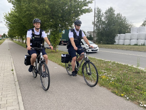 Policjanci na rowerach podczas patrolowania ulic miasta.