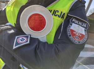 Policjant trzymający tarczę do zatrzymywania pojazdów.