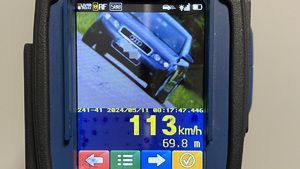 Urządzenie do pomiaru prędkości na ekranie którego widać ciemnu samochód oraz prędkość z jaka jechał 113 kilometrów na godzinę.