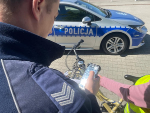 Policjant podczas znakowania roweru.