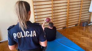 Policjantka podczas toru sprawności fizycznej wraz z ćwiczącym.