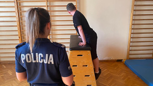 Policjantka podczas toru sprawności fizycznej wraz z ćwiczącym.